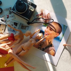 varios objetos sobre una mesa, tijeras, fotos, muñecas y bandera de españa